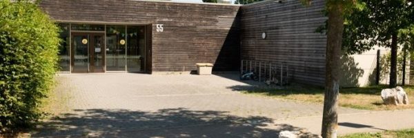 Eine moderne, einstöckige Kita in der Lautenbacher Straße mit Holzverkleidung und großen Glastüren.