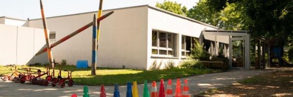 Eine Reihe bunter Verkehrsleitkegel säumt den Weg vor der modernen Kindertageseinrichtung in der Danziger Straße.