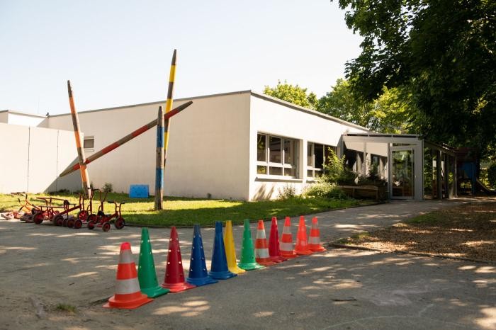Eine Reihe bunter Verkehrsleitkegel säumt den Weg vor der modernen Kindertageseinrichtung in der Danziger Straße.