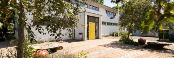 Eine moderne Kindertageseinrichtung am Gerokweg mit weißen Wänden und großen Fenstern.